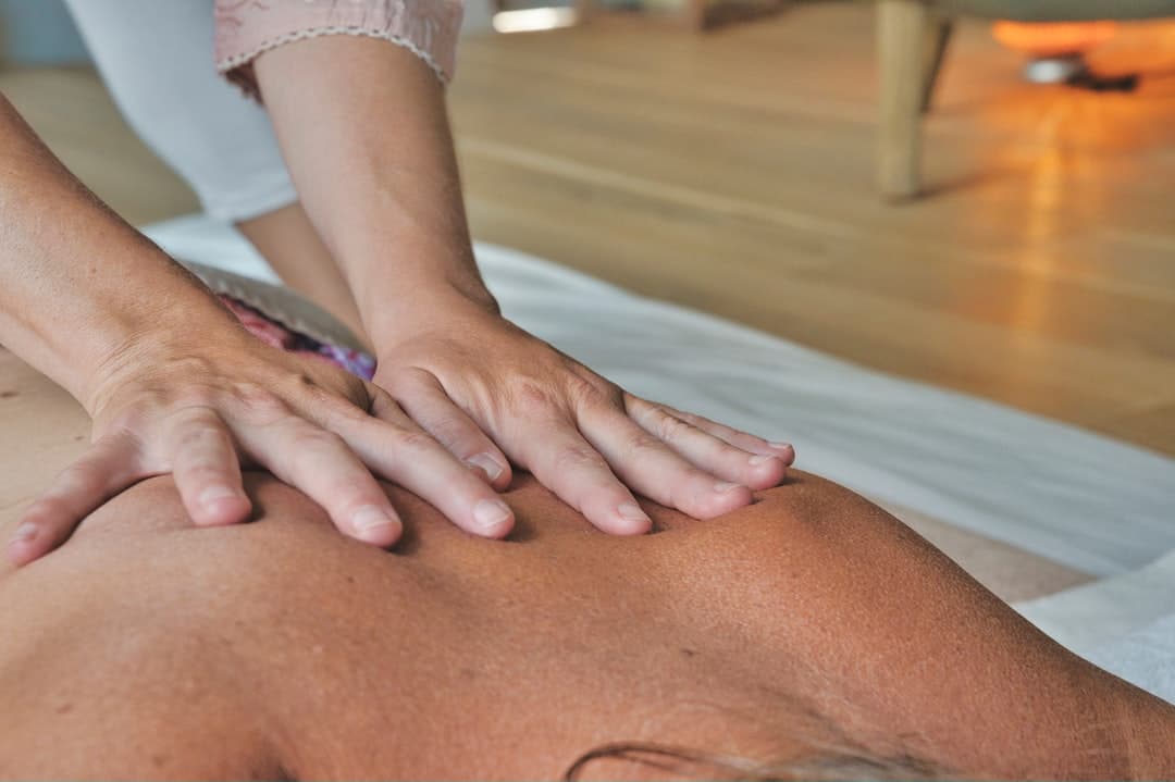 Persona apretando con la mano el músculo trapecio en gesto de aliviar tensión