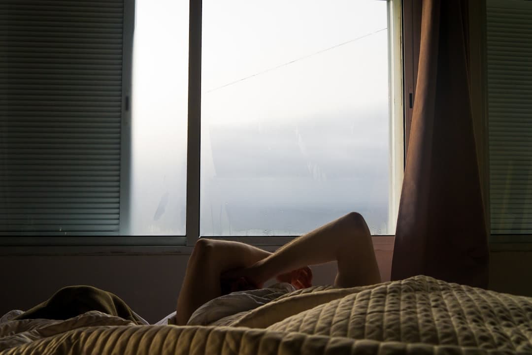 Persona haciendo el estiramiento postura del niño en una esterilla junto a la cama