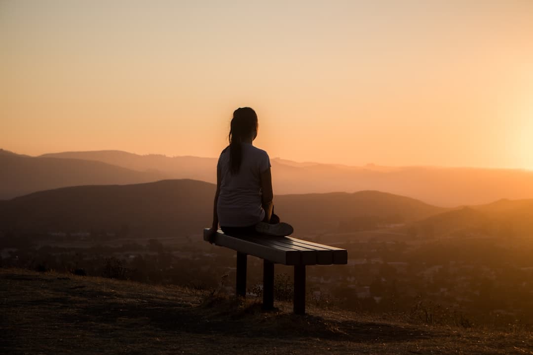 Persona meditando en postura de loto con los ojos cerrados en un entorno tranquilo y luminoso