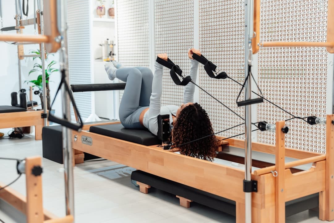 Paciente realizando ejercicios de pilates clínico supervisado por un fisioterapeuta en una sala de rehabilitación